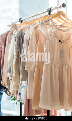 Set of light colored dresses on a wooden hangers Stock Photo