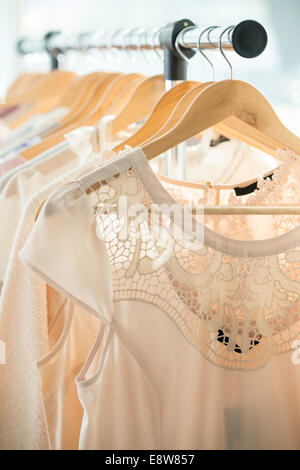 Set of light colored dresses on a wooden hangers Stock Photo