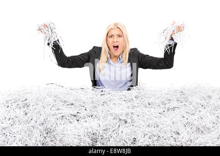 Angry businesswoman in a pile of shredded paper Stock Photo