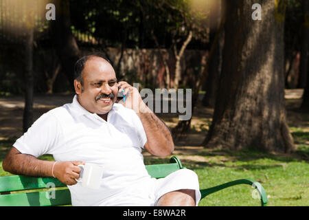 1 Indian Man Talking with Mobile in park Stock Photo