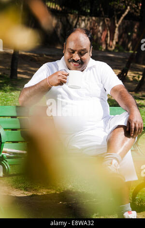 1 Indian Man Sitting in Park and Drinking Tea Stock Photo