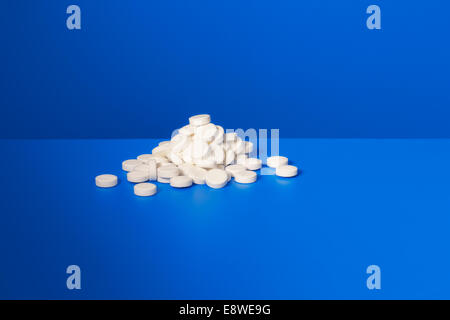 Pile of prescription pills on blue counter Stock Photo