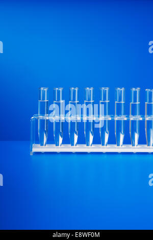 Rack of test tubes with solution on blue counter Stock Photo