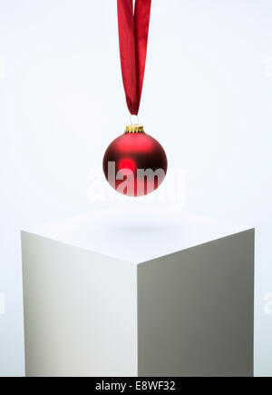 Christmas ornament hanging from ribbon over pedestal Stock Photo