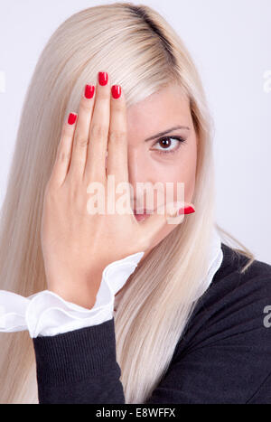 Beautiful young woman hiding his face with hands Stock Photo