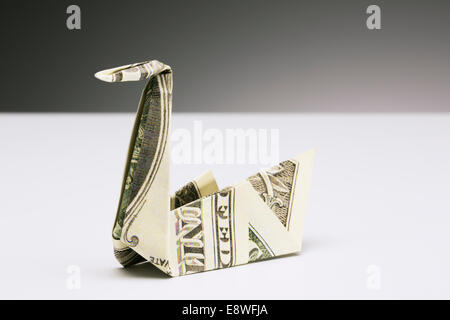 Origami swan made of dollar bill on counter Stock Photo