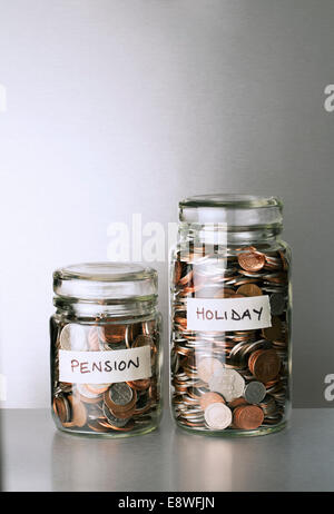 Pension and holiday change savings jars on counter Stock Photo