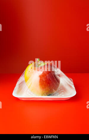 Close up of apple shrink wrapped in plastic Stock Photo