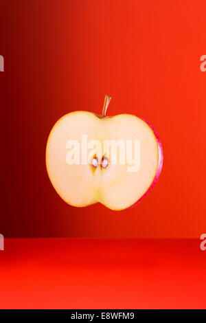 Apple slice on red counter Stock Photo