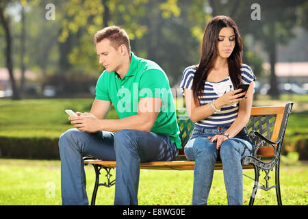 Conflicted couple not talking to each other seated on a wooden bench in park Stock Photo