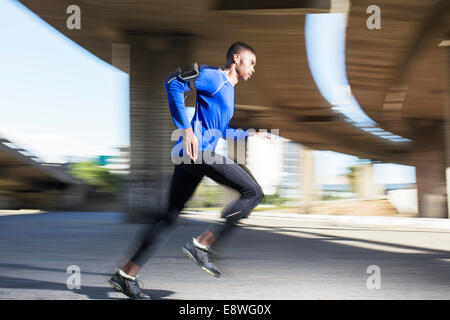 Man running through city streets Stock Photo