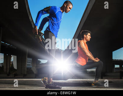 Men stretching before exercising on city street Stock Photo