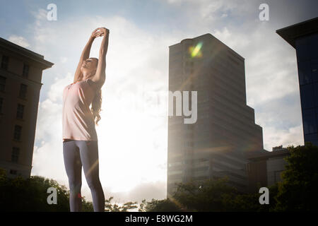 Arms, stretching or fitness woman by city wall in Indonesia or