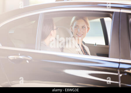Businesswomen talking in car back seat Stock Photo