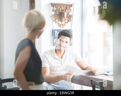 Man ordering from waitress talking in cafe Stock Photo