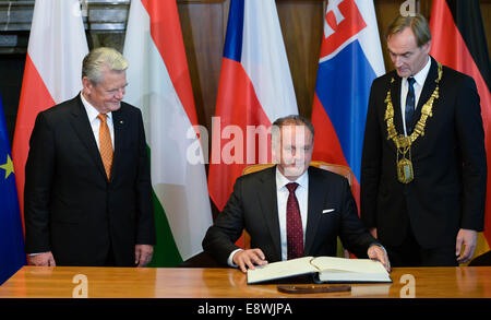 Leipzig, Germany. 09th Oct, 2014. German President Joachim Gauck (L) watches as Slovak President Andrej Kiska (C) signs the Golden Book of the city of Leipzig next to Leipzig's Lord Mayor Burkhard Jung (SPD, R) in Leipzig, Germany, 09 October 2014. The ceremony was held on the occasion of the 25th anniversary of the 'Peaceful Revolution' in Leipzig. Photo: Peter Endig/ZB/dpa/Alamy Live News Stock Photo