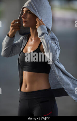 Woman putting on sweatshirt after exercise Stock Photo