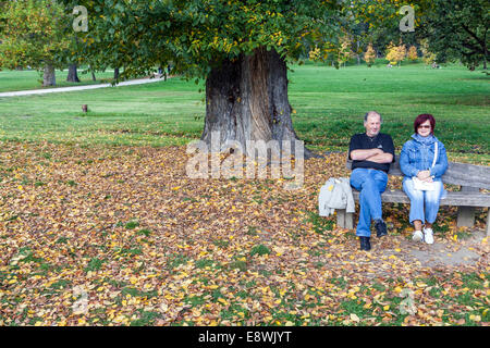 People in the city garden, Couple - woman man on a bench, Stromovka park Prague Autumn Czech Republic Senior bench senior couple sitting in the park Stock Photo