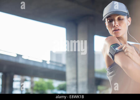 Woman playing music before exercising Stock Photo