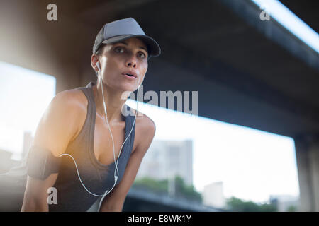 Woman resting after exercising on city street Stock Photo
