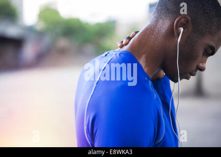 Man resting after exercising on city street Stock Photo