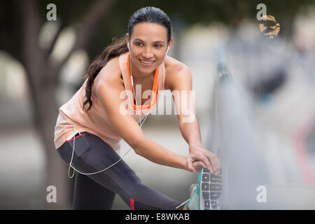 Woman stretching before exercising on city street Stock Photo