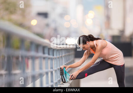 Woman stretching before exercising on city street Stock Photo