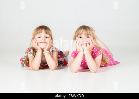two little girls laying on floor and looking up Stock Photo