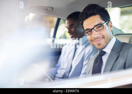 Businessman using digital tablet in car back seat Stock Photo