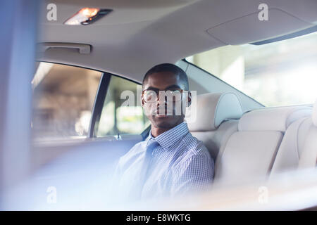 Businessman sitting in car back seat Stock Photo