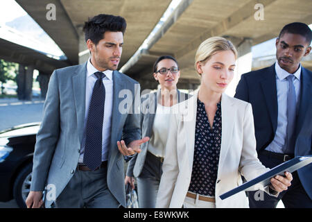 Business people walking under city overpass Stock Photo