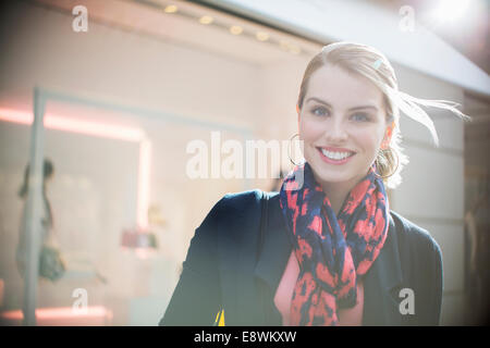 Woman standing in front of store in city Stock Photo