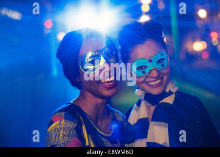 Women in masks smiling together Stock Photo