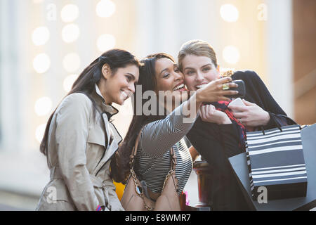 Friends talking picture with cell phone together on city street Stock Photo
