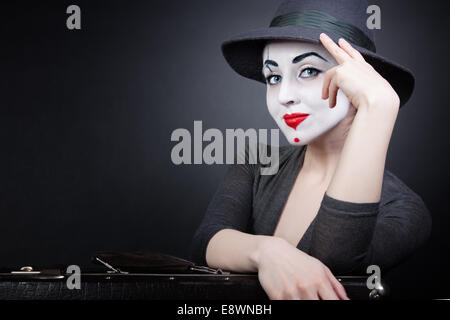 Portrait of woman mime with a suitcase on a black background Stock Photo