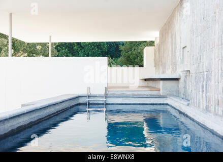 Stone wall and steps in covered pool Stock Photo