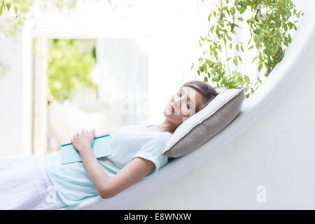 Woman relaxing on pillow outdoors Stock Photo
