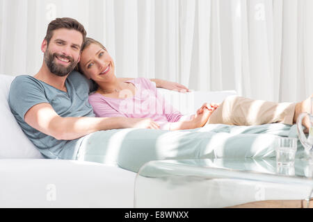 Couple relaxing together on sofa in modern living room Stock Photo