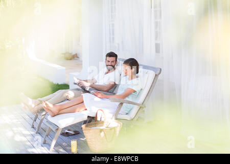 Couple relaxing together in lawn chairs outdoors Stock Photo