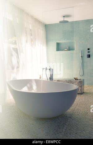 Water pouring into bathtub in modern bathroom Stock Photo