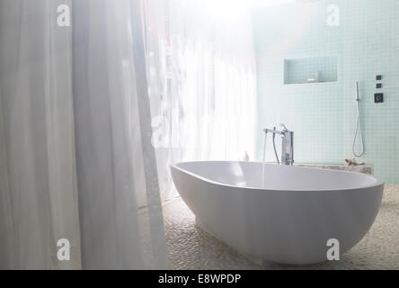 Water pouring into bathtub in modern bathroom Stock Photo