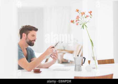 Man reading newspaper at breakfast