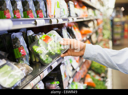 Close up of man holding produce in grocery store Stock Photo