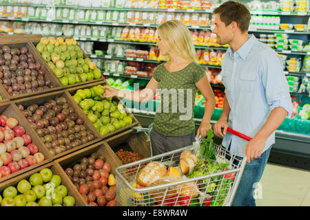Couple shopping together in produce section of grocery store Stock Photo