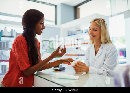 Woman discussing skincare product with pharmacist in drugstore Stock Photo