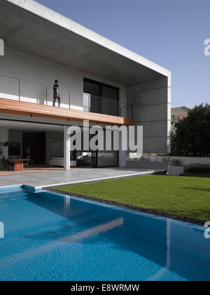 Man walking along double height balcony facade of D House with swimming pool, Israel, Middle East. Stock Photo