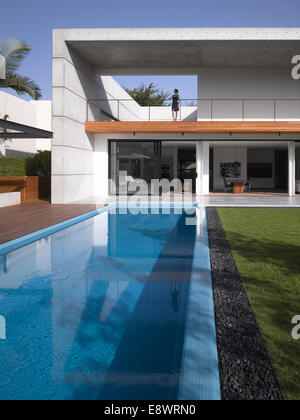 Woman stands on double height balcony facade of D House with swimming pool, Israel, Middle East. Stock Photo