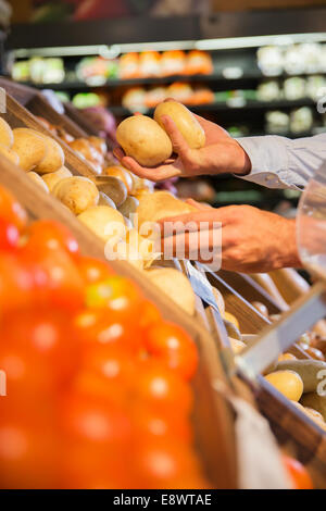 Close up of man selecting produce in grocery store Stock Photo