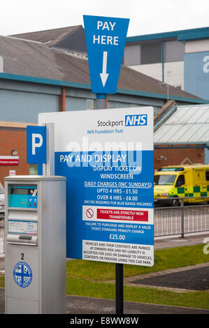 Pay and Display meter to issue tickets, and charges / parking charging rate sign, in an NHS hospital Car Park. UK Stock Photo