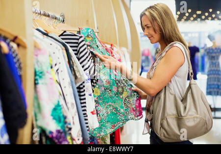 Woman checking price tags while shopping in clothing store Stock Photo